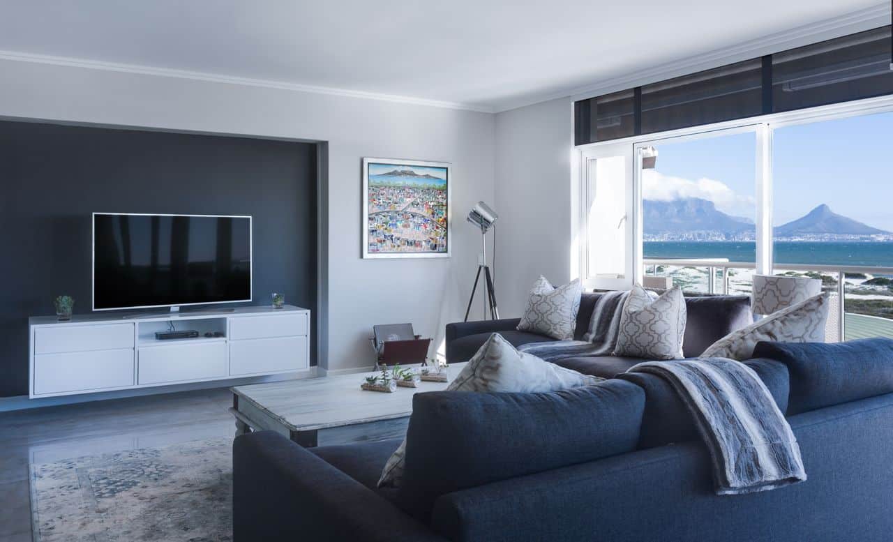 Bright, modern luxury suite living room with comfortable sofas and large windows