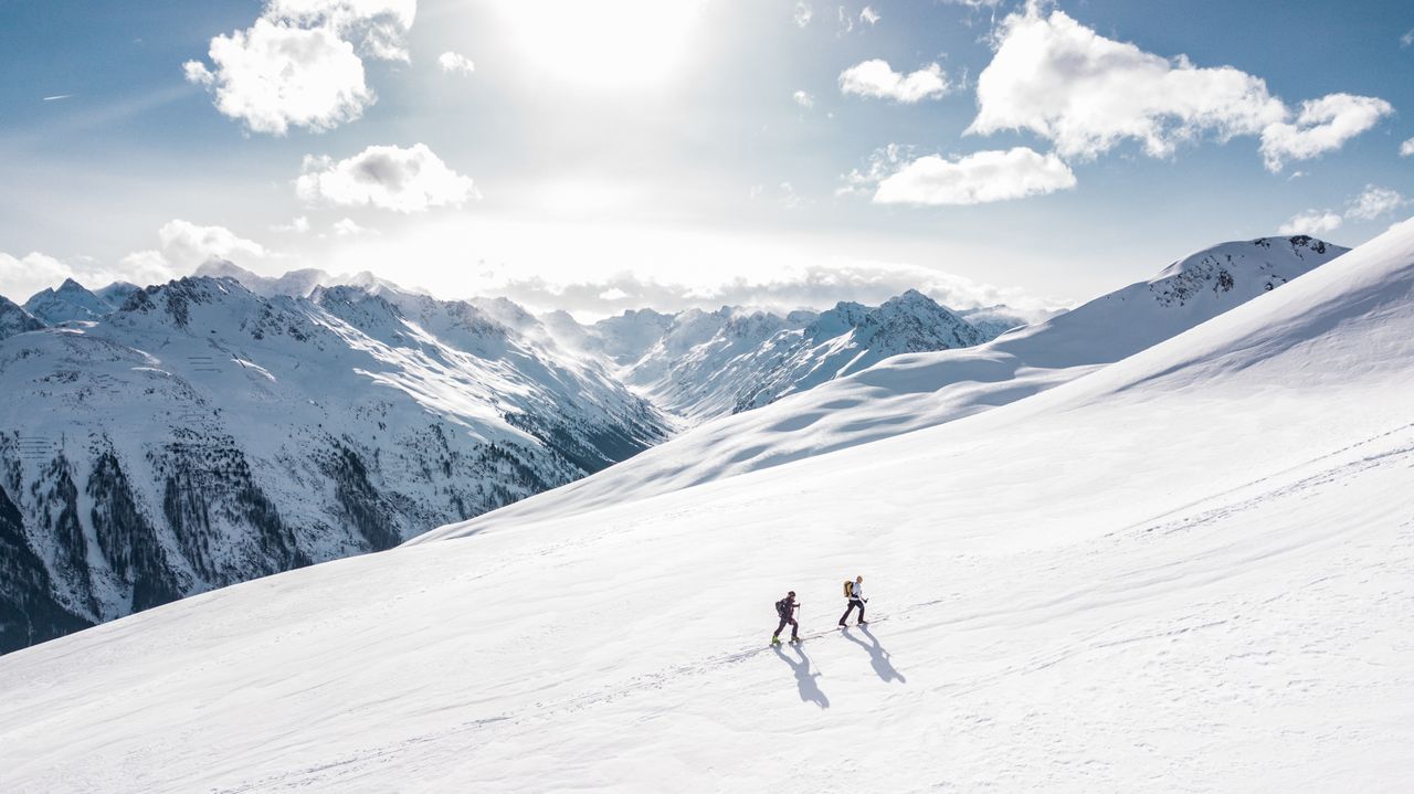 Snow-covered Rocky Mountain peaks near Banff in winter with ski slopes and pine forest